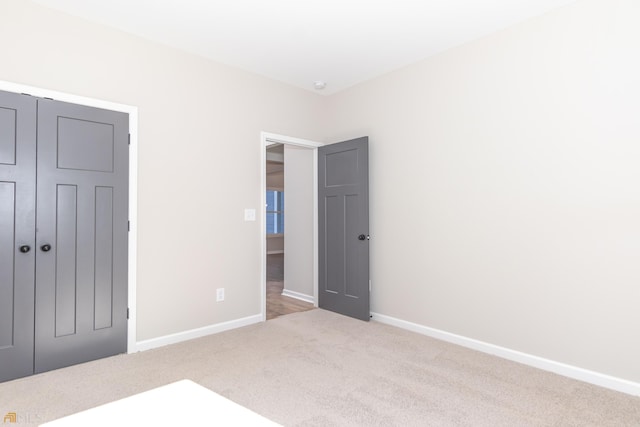 unfurnished bedroom featuring light colored carpet and a closet