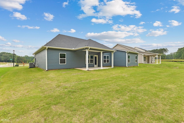 back of house featuring a lawn, a patio area, and central air condition unit