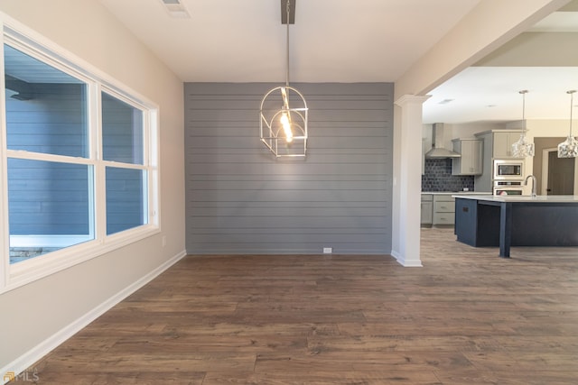 unfurnished dining area featuring a chandelier and dark hardwood / wood-style floors