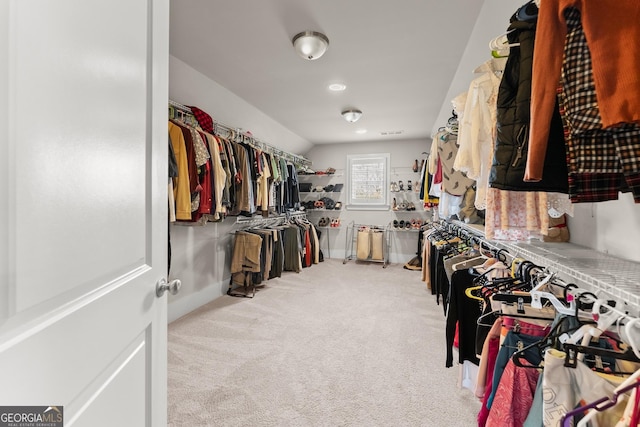 walk in closet featuring light carpet