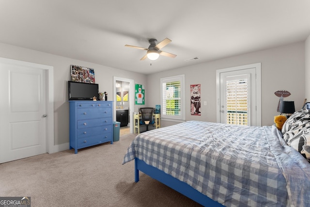 bedroom with access to outside, connected bathroom, light colored carpet, and ceiling fan