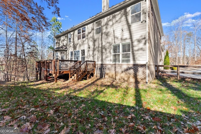 rear view of property with a yard and a deck