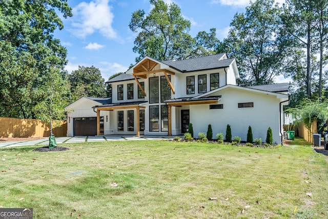 back of house featuring a lawn and a garage