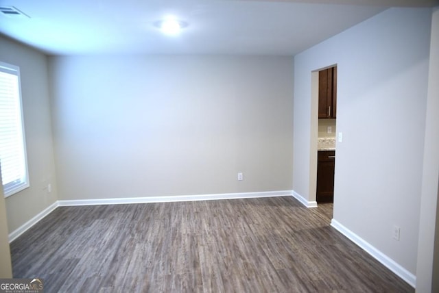 unfurnished room featuring dark hardwood / wood-style floors and a healthy amount of sunlight