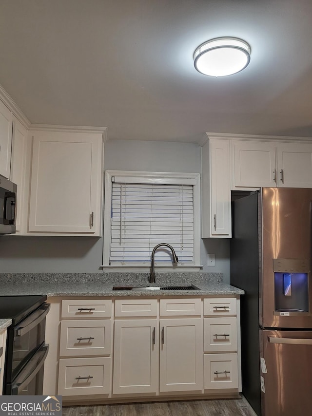 kitchen featuring appliances with stainless steel finishes, white cabinetry, and sink