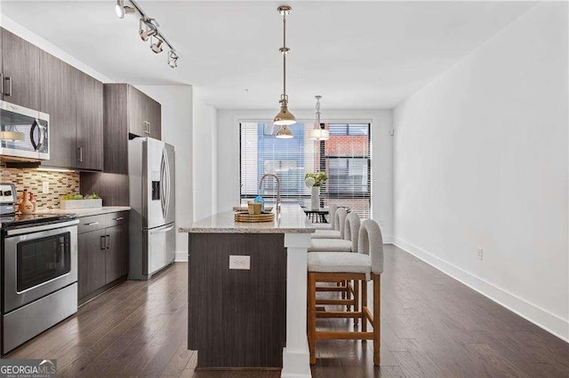 966 Moda Dr, Atlanta, GA 30316 - kitchen featuring dark hardwood / wood-style floors, dark brown cabinets, stainless steel appliances, and a center island with sink