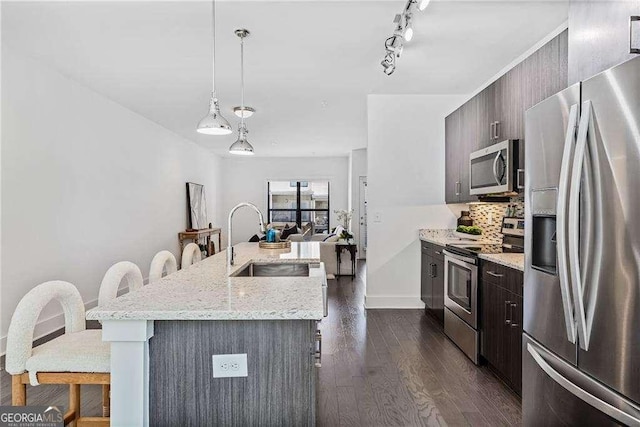 966 Moda Dr, Atlanta, GA 30316 - kitchen with a kitchen bar, dark hardwood / wood-style flooring, a center island with sink, and stainless steel appliances