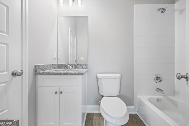 full bathroom featuring tiled shower / bath combo, vanity, hardwood / wood-style flooring, and toilet