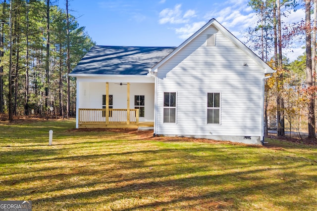 rear view of property featuring ceiling fan, a porch, and a lawn