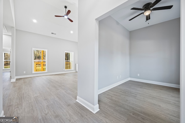 unfurnished room featuring high vaulted ceiling, ceiling fan, and light wood-type flooring