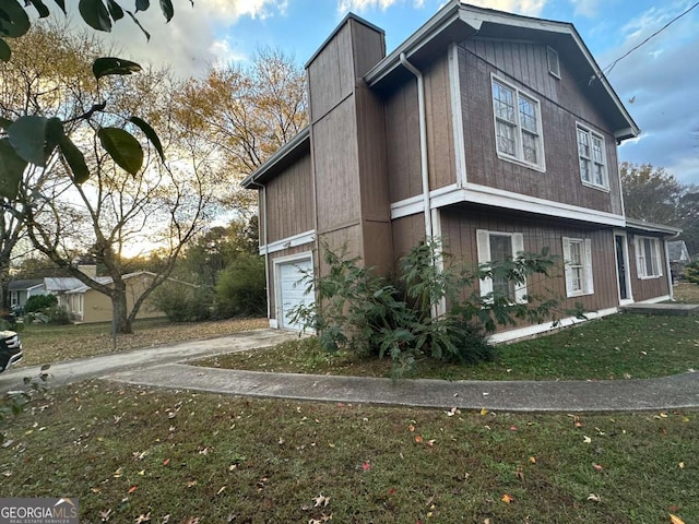 view of side of home with a yard and a garage