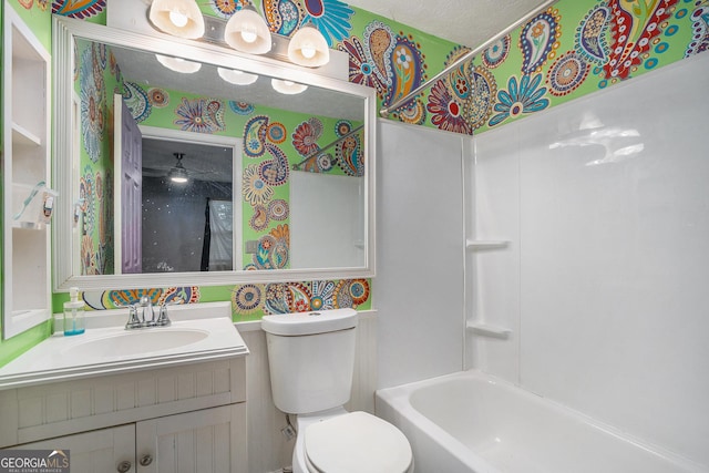 full bathroom featuring vanity, a textured ceiling, toilet, and shower / bathtub combination