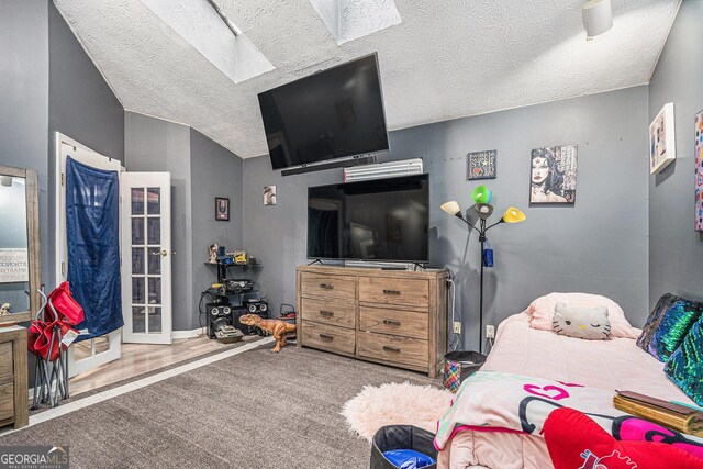 carpeted bedroom featuring a textured ceiling and a skylight