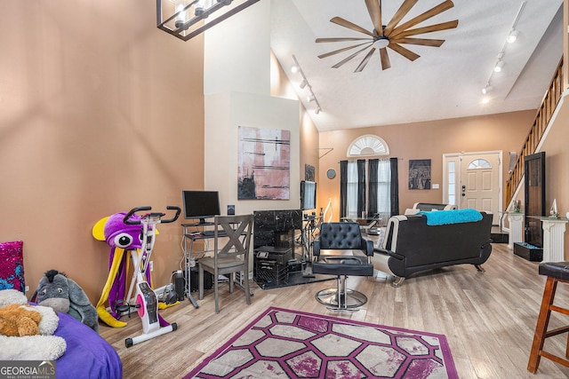 living room with track lighting, high vaulted ceiling, and light hardwood / wood-style flooring