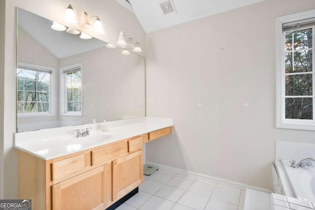 bathroom featuring tile patterned flooring, vanity, a tub, and vaulted ceiling