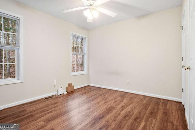 spare room featuring hardwood / wood-style flooring, plenty of natural light, and ceiling fan