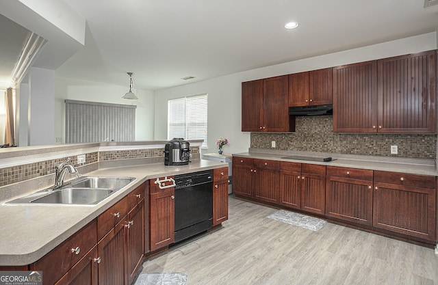 kitchen with pendant lighting, black appliances, sink, light wood-type flooring, and tasteful backsplash