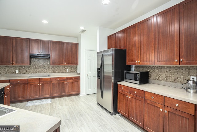 kitchen featuring decorative backsplash, stainless steel appliances, and light hardwood / wood-style floors