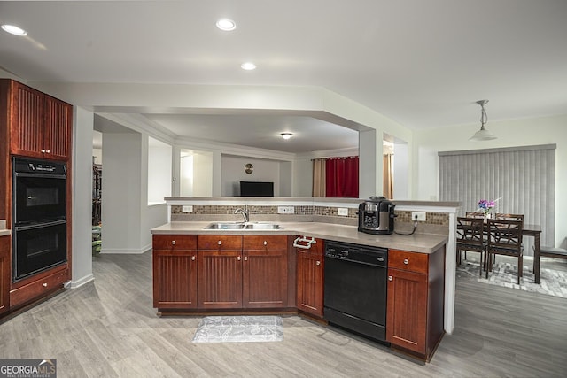 kitchen featuring black appliances, light wood-type flooring, sink, and hanging light fixtures