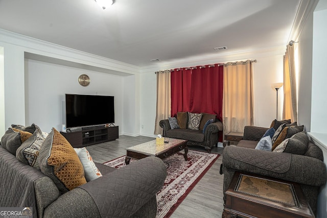 living room with wood-type flooring and ornamental molding