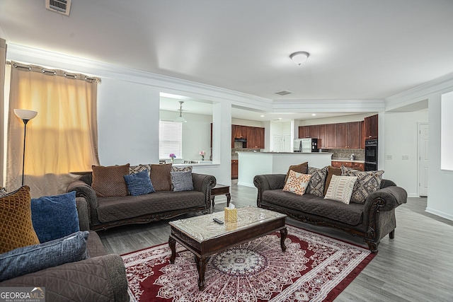 living room featuring wood-type flooring and ornamental molding