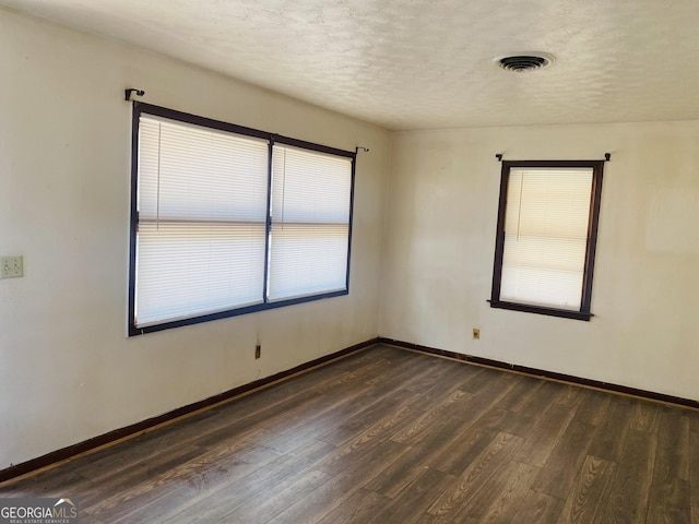 unfurnished room featuring a textured ceiling and dark wood-type flooring