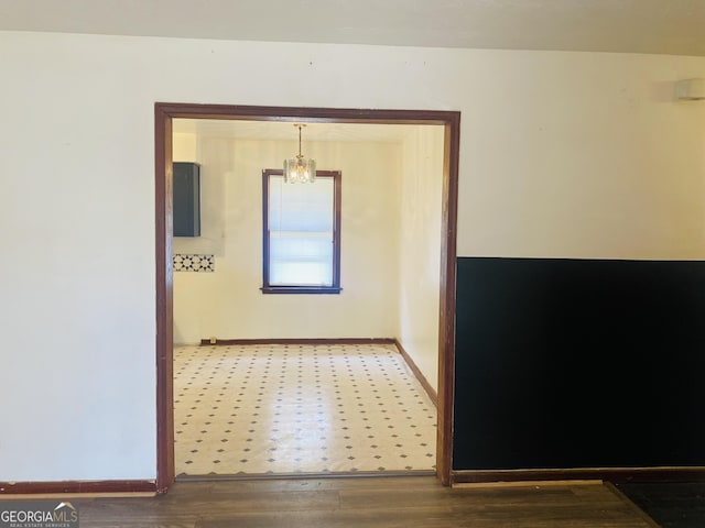 hallway featuring an inviting chandelier and hardwood / wood-style flooring