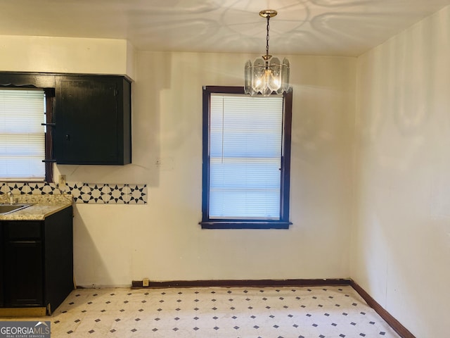 unfurnished dining area featuring sink and an inviting chandelier