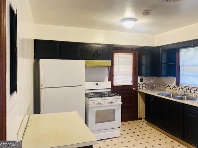 kitchen featuring white appliances, backsplash, and sink