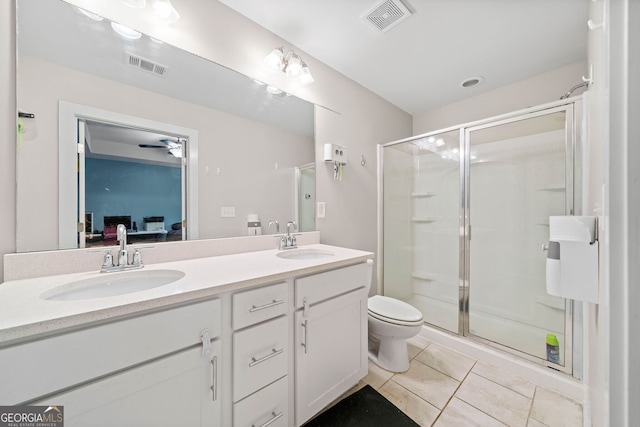 bathroom featuring tile patterned flooring, vanity, a shower with door, and toilet