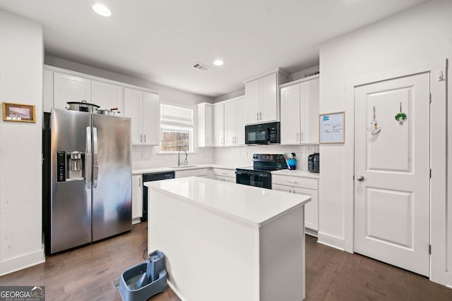 kitchen with black appliances, a kitchen island, white cabinetry, and dark wood-type flooring