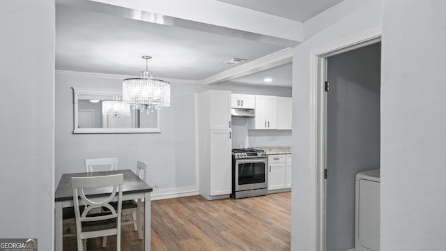 kitchen featuring white cabinetry, ornamental molding, hardwood / wood-style flooring, and stainless steel range with gas stovetop