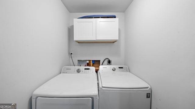 washroom with cabinets and washer and clothes dryer