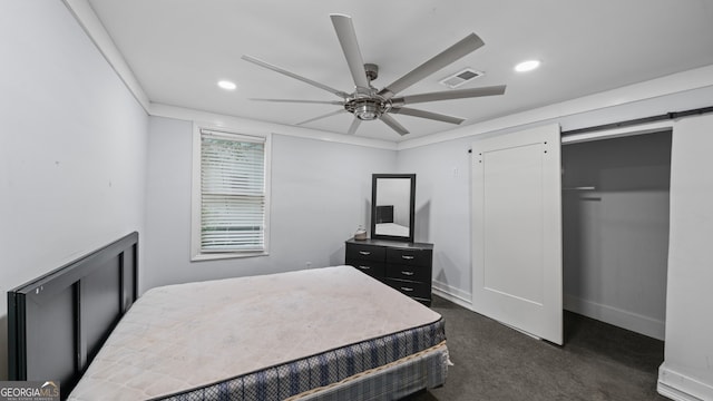 carpeted bedroom featuring a barn door and ceiling fan