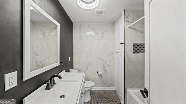 bathroom with tile patterned floors, vanity, toilet, and tile walls