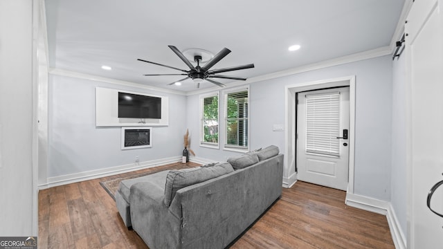 living room with hardwood / wood-style floors, a barn door, and crown molding