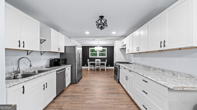 kitchen featuring sink, white cabinets, stainless steel appliances, and wood-type flooring