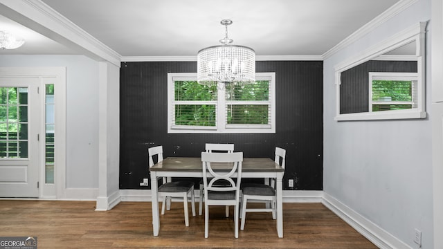 dining area featuring hardwood / wood-style floors, ornamental molding, and an inviting chandelier