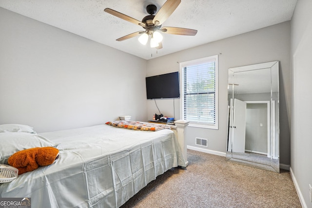 bedroom featuring carpet, a textured ceiling, and ceiling fan