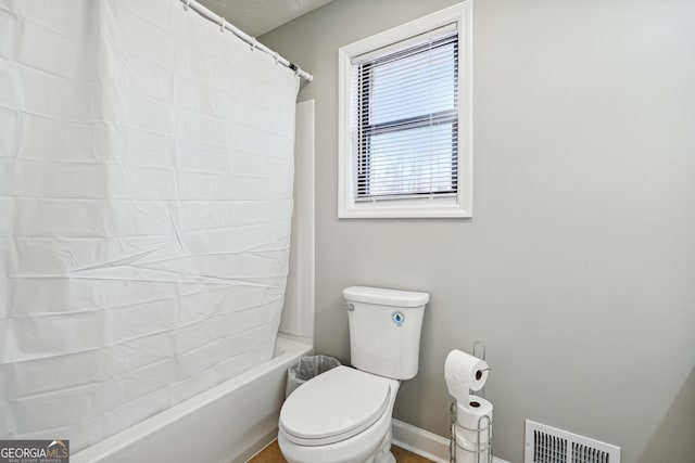 bathroom with shower / bath combo and toilet