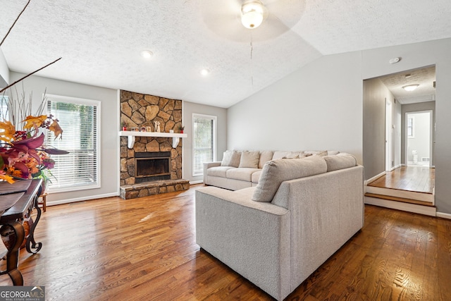 living room featuring a textured ceiling, lofted ceiling, and hardwood / wood-style flooring