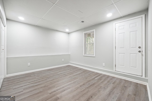 unfurnished room with light hardwood / wood-style flooring and a drop ceiling