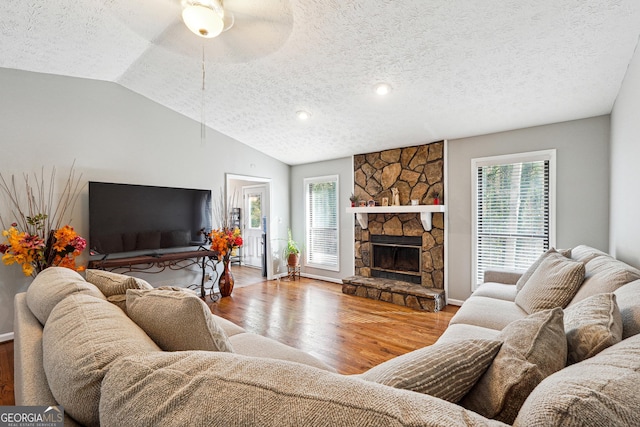 living room with hardwood / wood-style floors, plenty of natural light, a textured ceiling, and vaulted ceiling