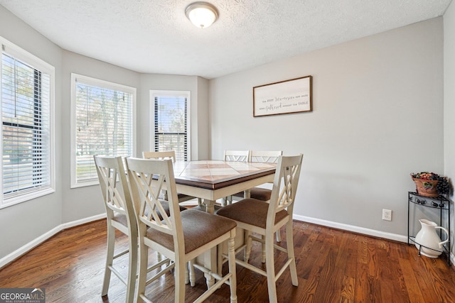 dining room featuring a textured ceiling and dark wood-type flooring