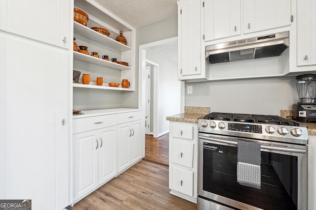 kitchen with white cabinets, stainless steel gas stove, a textured ceiling, and light hardwood / wood-style flooring