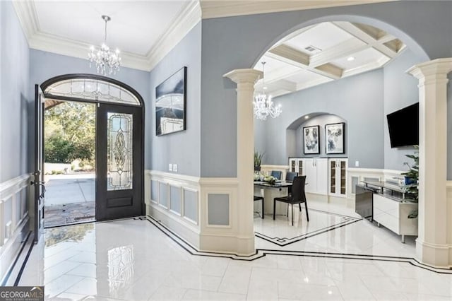 foyer entrance with beam ceiling, french doors, coffered ceiling, a chandelier, and ornamental molding