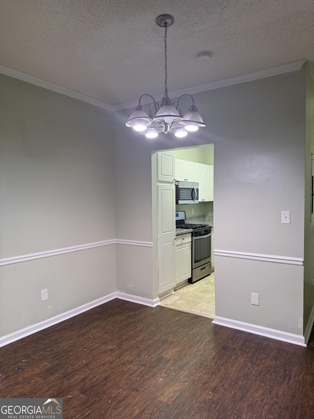 kitchen with stainless steel appliances, a notable chandelier, light hardwood / wood-style floors, a textured ceiling, and white cabinets