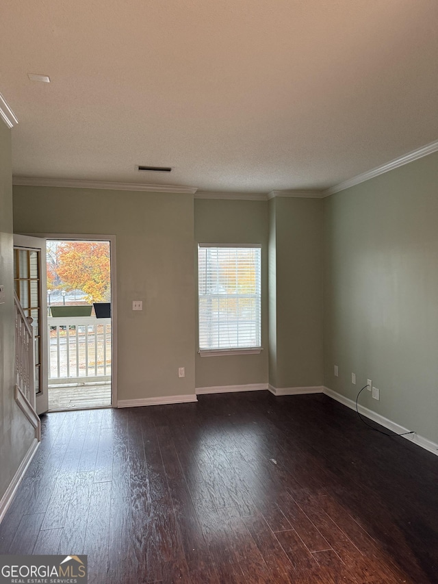 unfurnished room featuring a textured ceiling, dark hardwood / wood-style floors, and ornamental molding