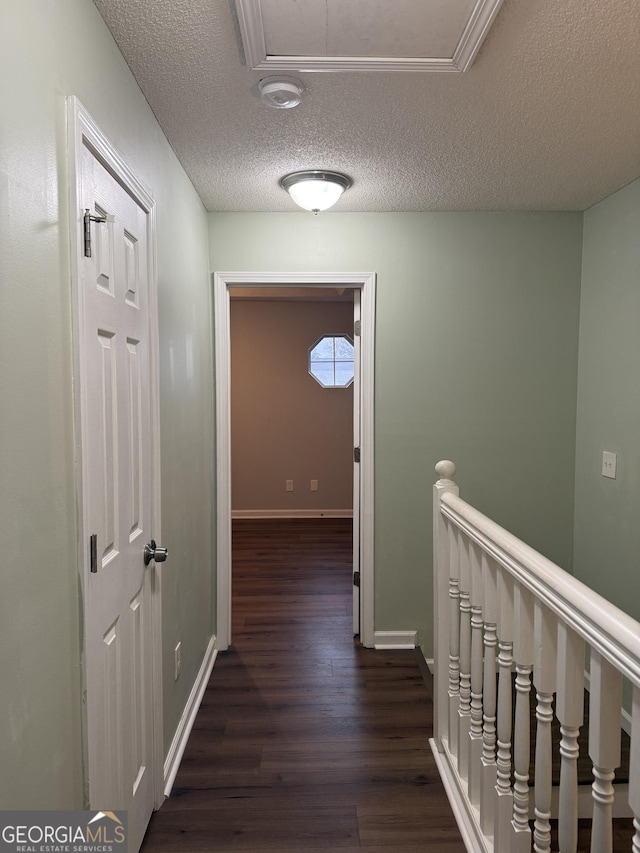 hall with a textured ceiling and dark hardwood / wood-style floors