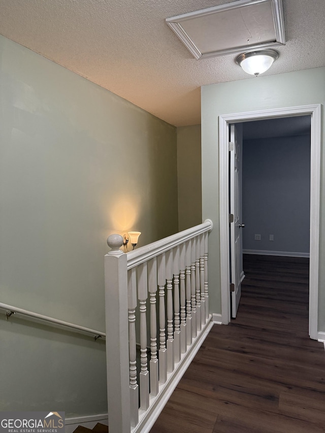 hallway featuring a textured ceiling and dark hardwood / wood-style floors